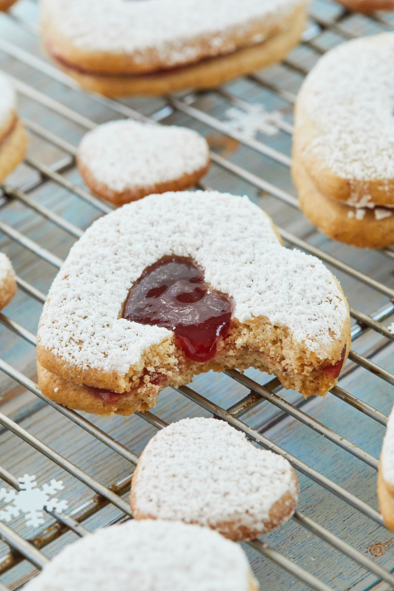 A linzer cookie with a bite taken out of it.