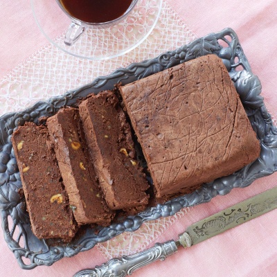 Mocha Pâté is sliced and served on a tray with two glass cups of coffee. It's a cross between rich fudge and velvety mousse, and studded with toasted hazelnuts that perfectly set off the dessert's lush texture.